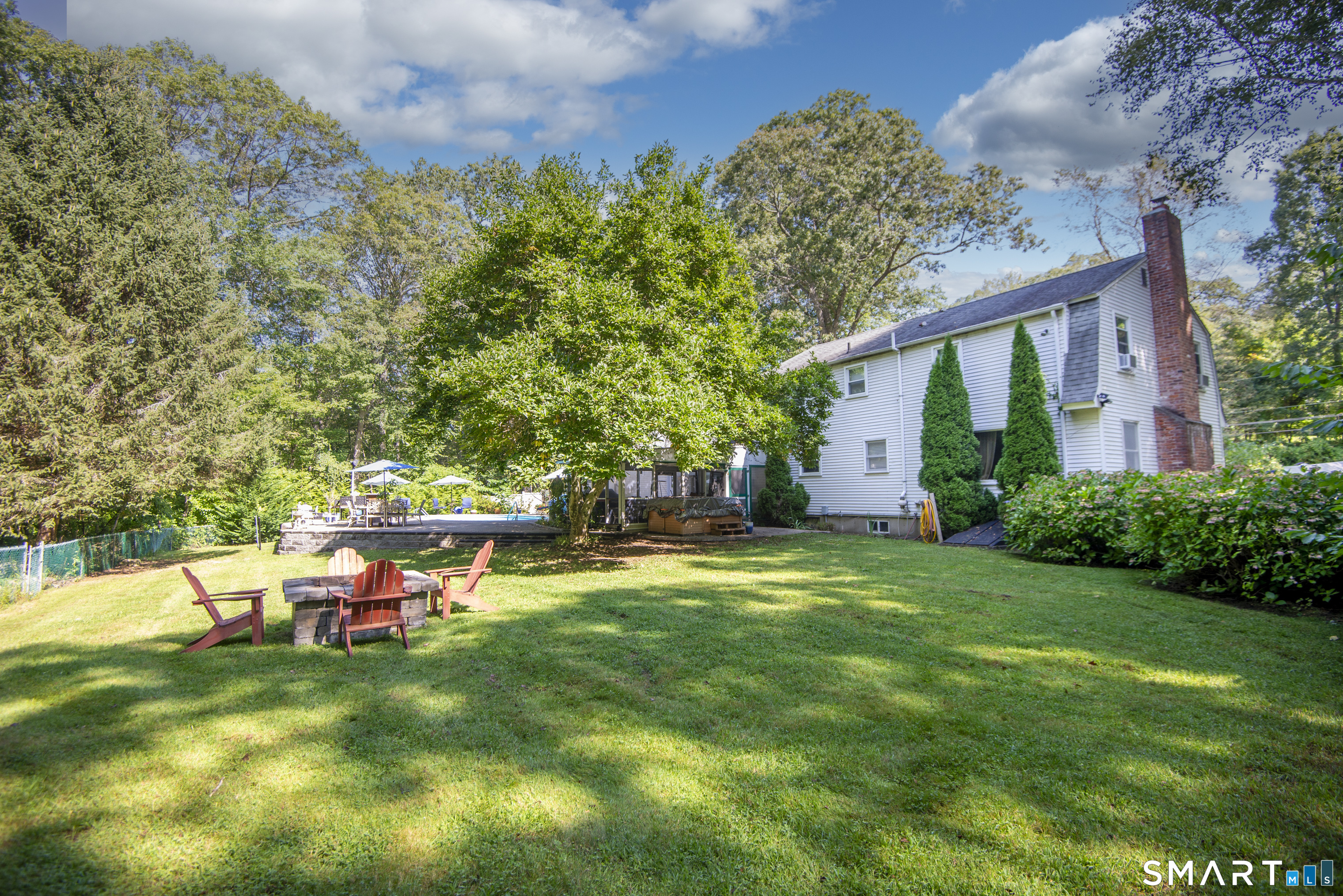 185 Ingham Hill Road Old Saybrook, CT 06475 - Photo 12 of 46 a backyard of a house with table and chairs and wooden fence