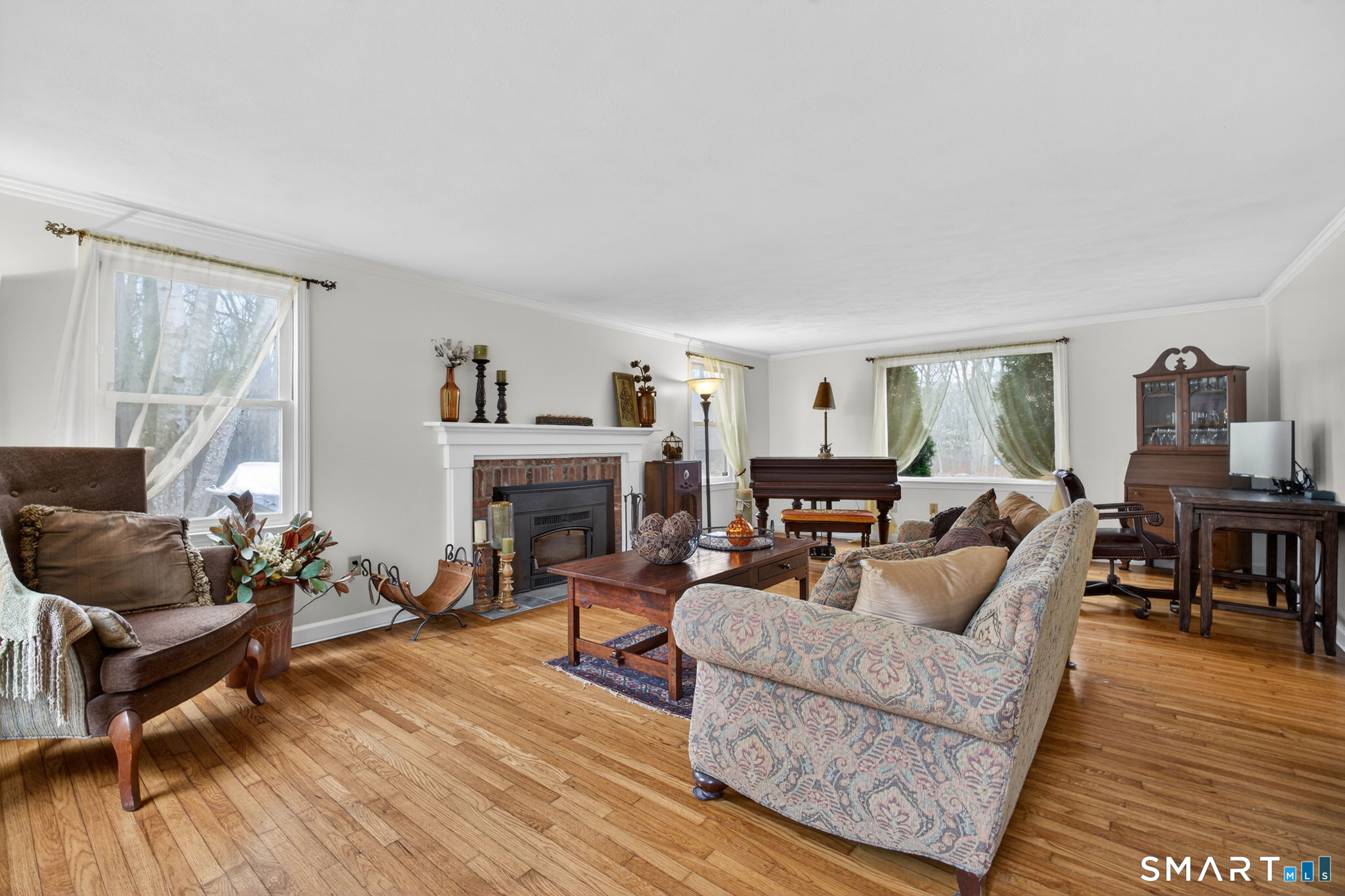 185 Ingham Hill Road Old Saybrook, CT 06475 - Photo 23 of 46 a living room with furniture a fireplace and a wooden floor