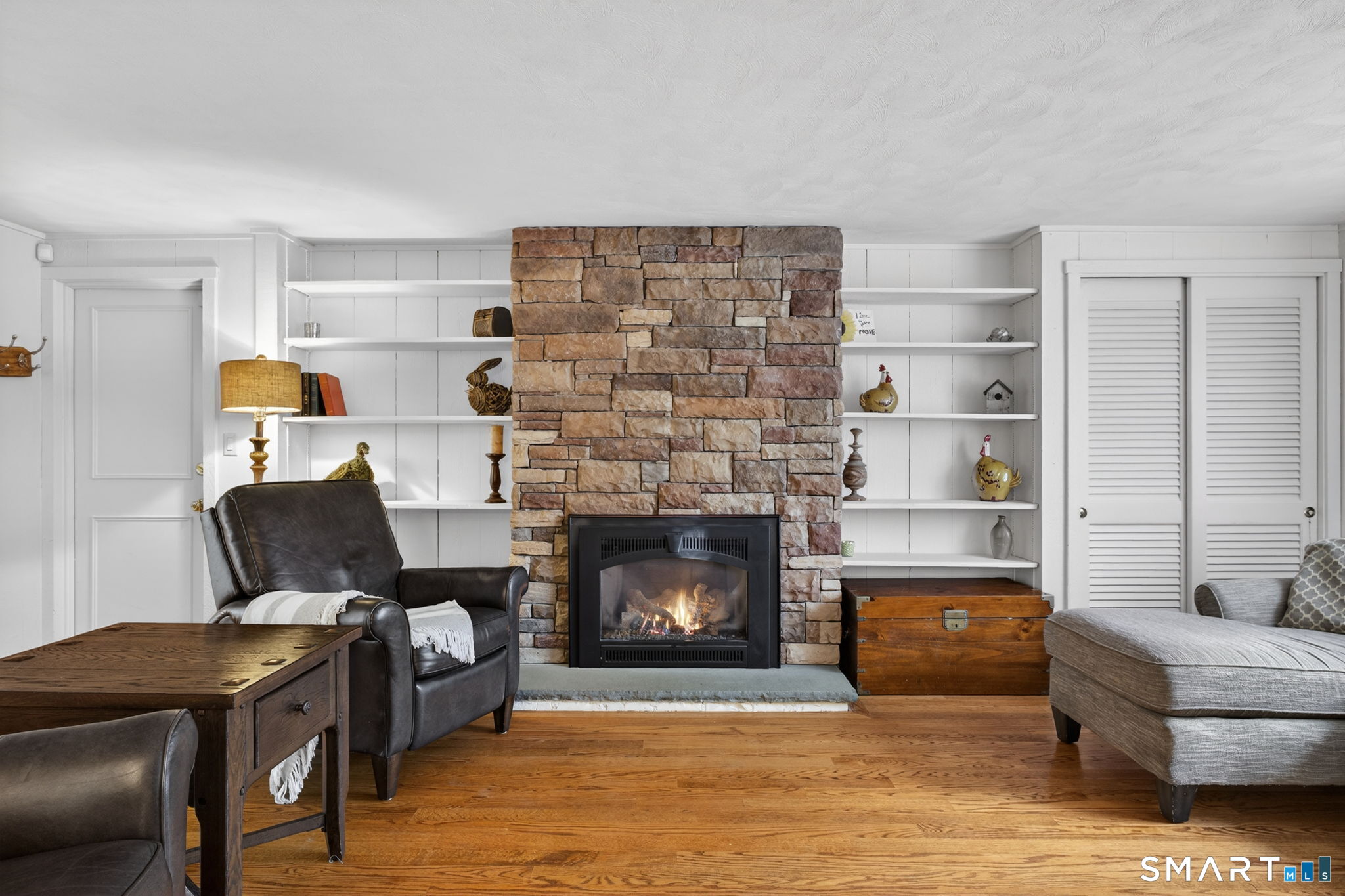 185 Ingham Hill Road Old Saybrook, CT 06475 - Photo 29 of 46 a living room with furniture and a fireplace