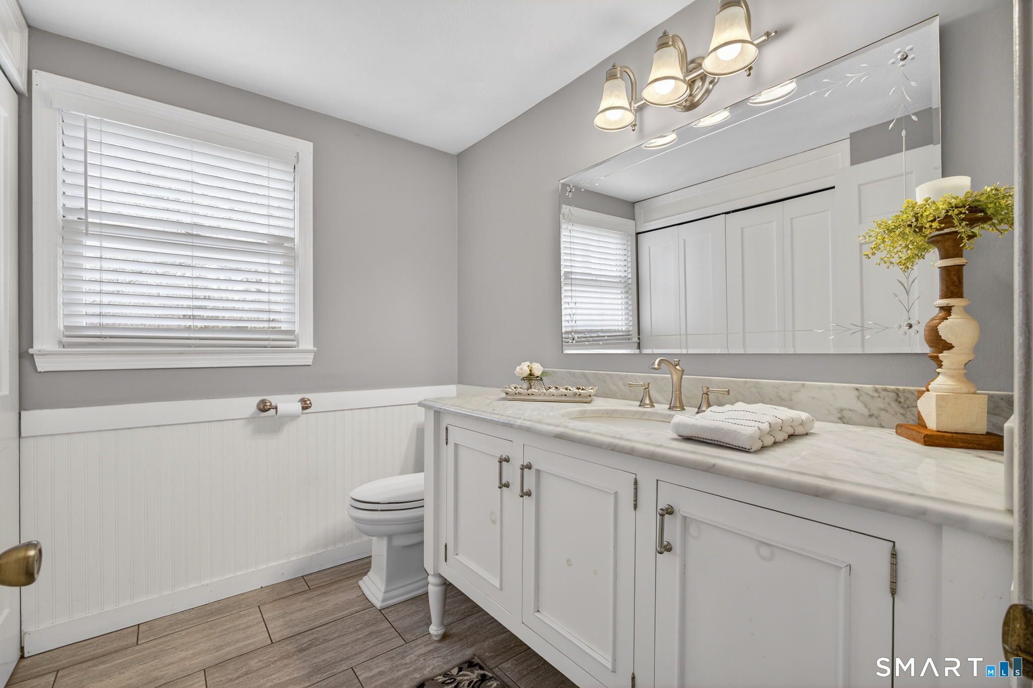185 Ingham Hill Road Old Saybrook, CT 06475 - Photo 44 of 46 a bathroom with a granite countertop sink a large mirror and a toilet