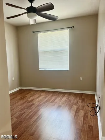 an empty room with a window and a ceiling fan