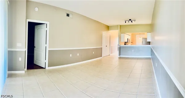 a view of a hallway with wooden floor and a bathroom