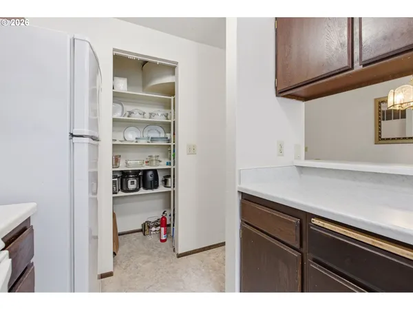 a kitchen view of a refrigerator and cabinets