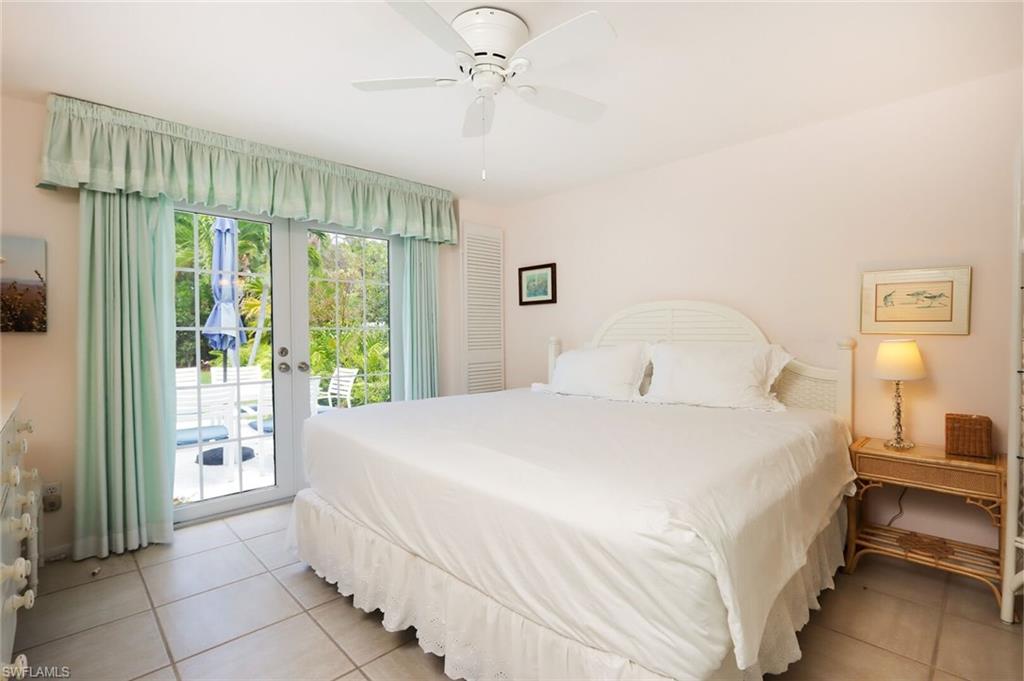 361 1st Avenue North Naples, FL 34102 - Photo 15 of 28 a bedroom with a bed and a chandelier