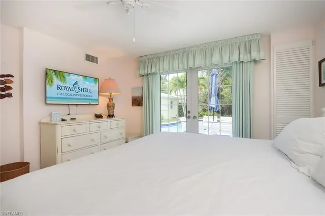 a bedroom with a large bed and a flat tv screen on dresser
