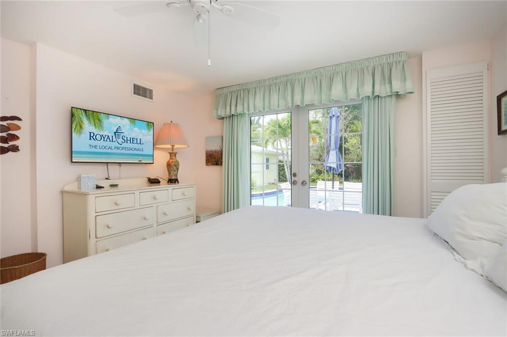 361 1st Avenue North Naples, FL 34102 - Photo 16 of 28 a bedroom with a large bed and a flat tv screen on dresser