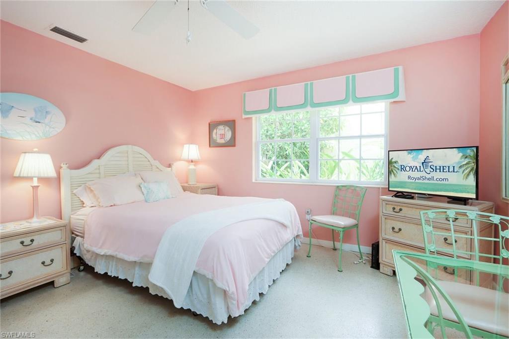 361 1st Avenue North Naples, FL 34102 - Photo 19 of 28 a bedroom with a bed and a flat tv screen on dresser