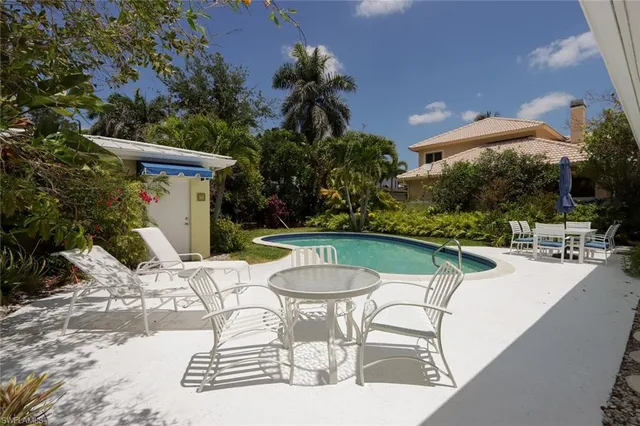 a view of a patio with a table and chairs potted plants and palm tree