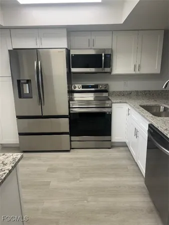 a kitchen with granite countertop a refrigerator and a stove