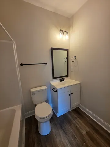 a bathroom with a toilet a sink and mirror