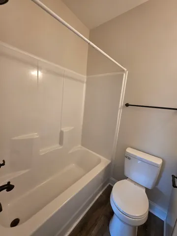 a white toilet sitting next to a bath tub