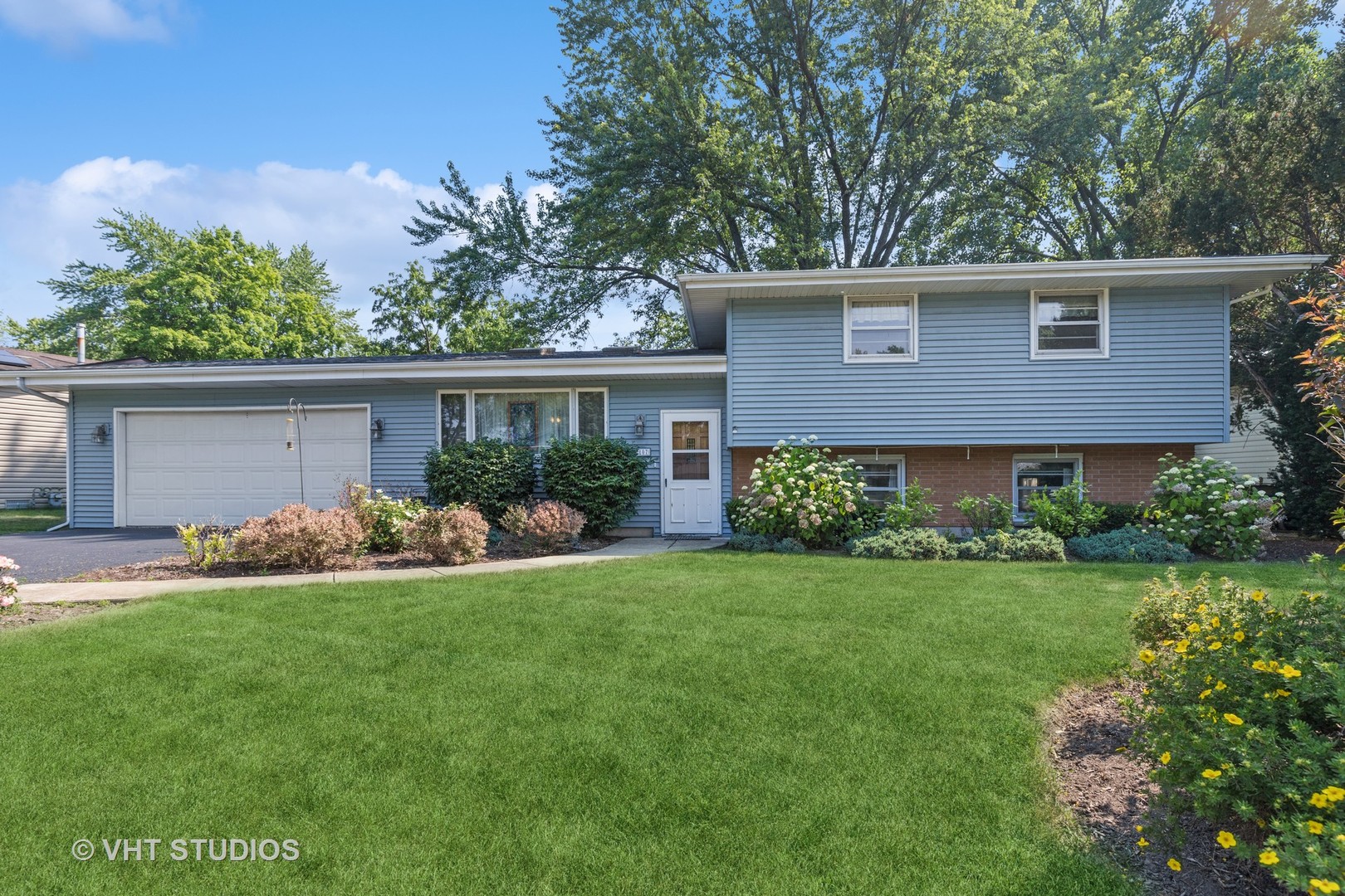 a view of a house with a yard and potted plants