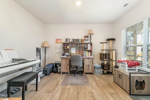 a view of a workspace with furniture and a window