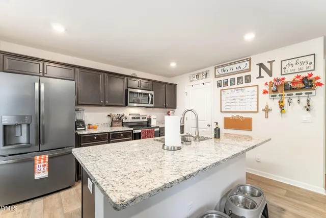 a kitchen with stainless steel appliances granite countertop a sink refrigerator and microwave