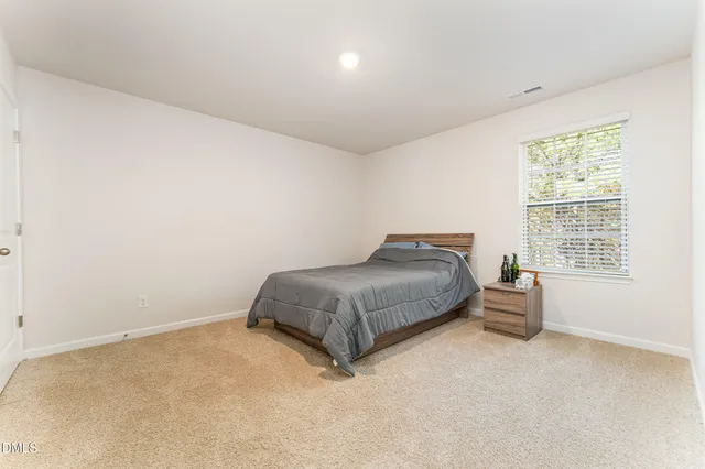 a spacious bedroom with a bed and window
