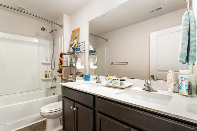 a bathroom with a sink a toilet a tub and shower