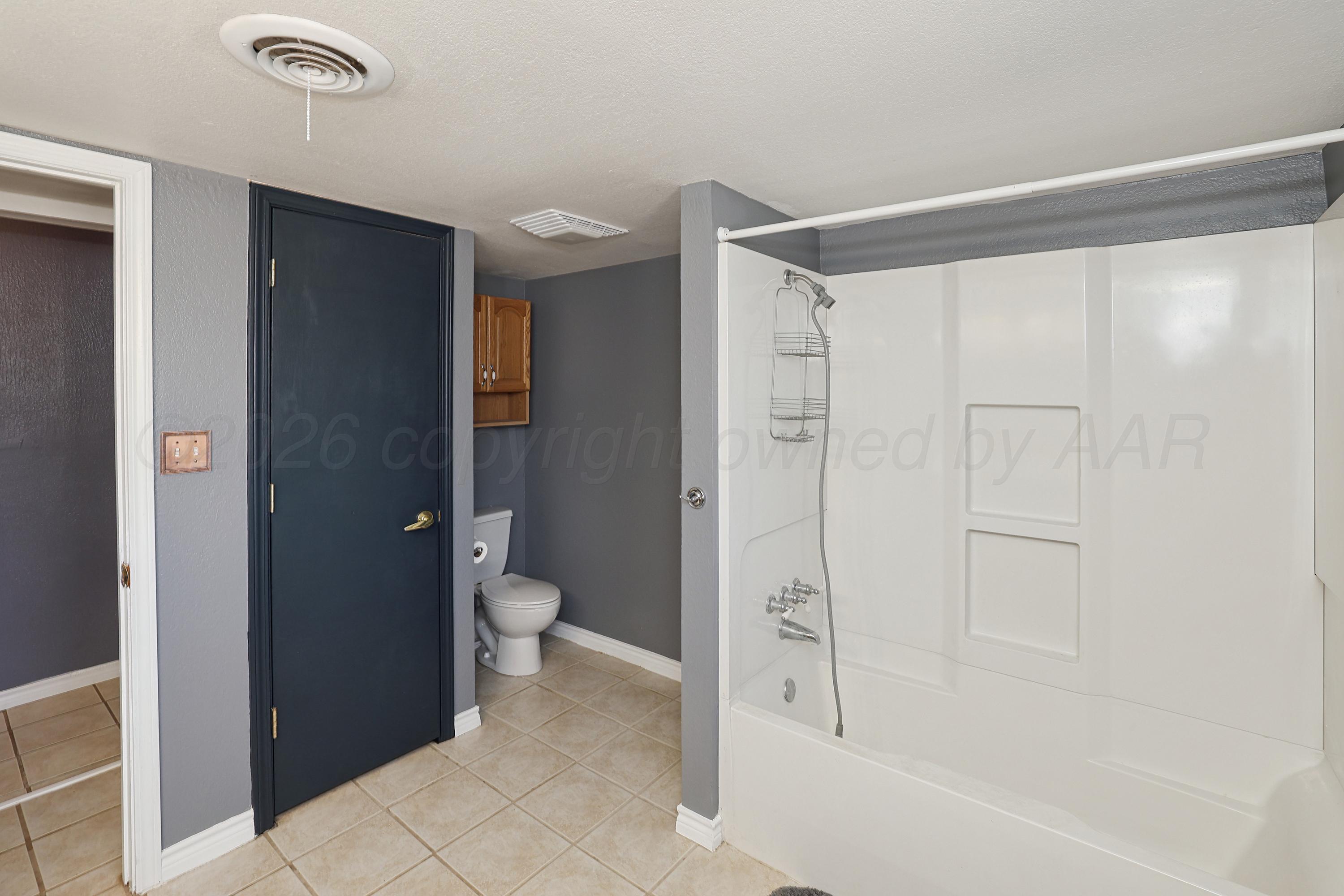 14200 Savannah Road Amarillo, TX 79118 - Photo 22 of 34 a bathroom with a granite countertop sink a toilet and shower