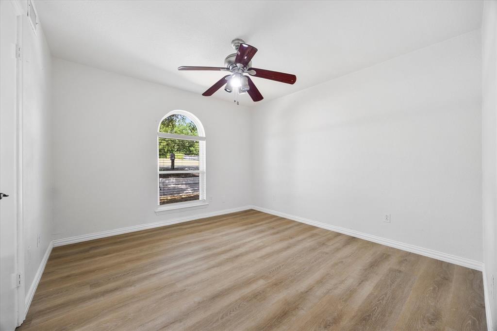 925 Lake North Road Rowlett, TX 75089 - Photo 22 of 37 Vaulted ceiling with a ceiling fan, arched window, wood-finish flooring, and white walls