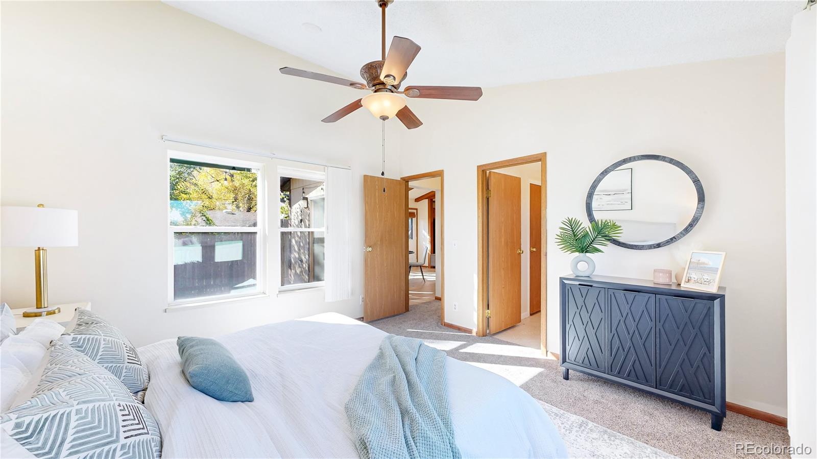 214 Poppy Street Golden, CO 80401 - Photo 12 of 31 a bedroom with a bed a mirror on dresser and a window