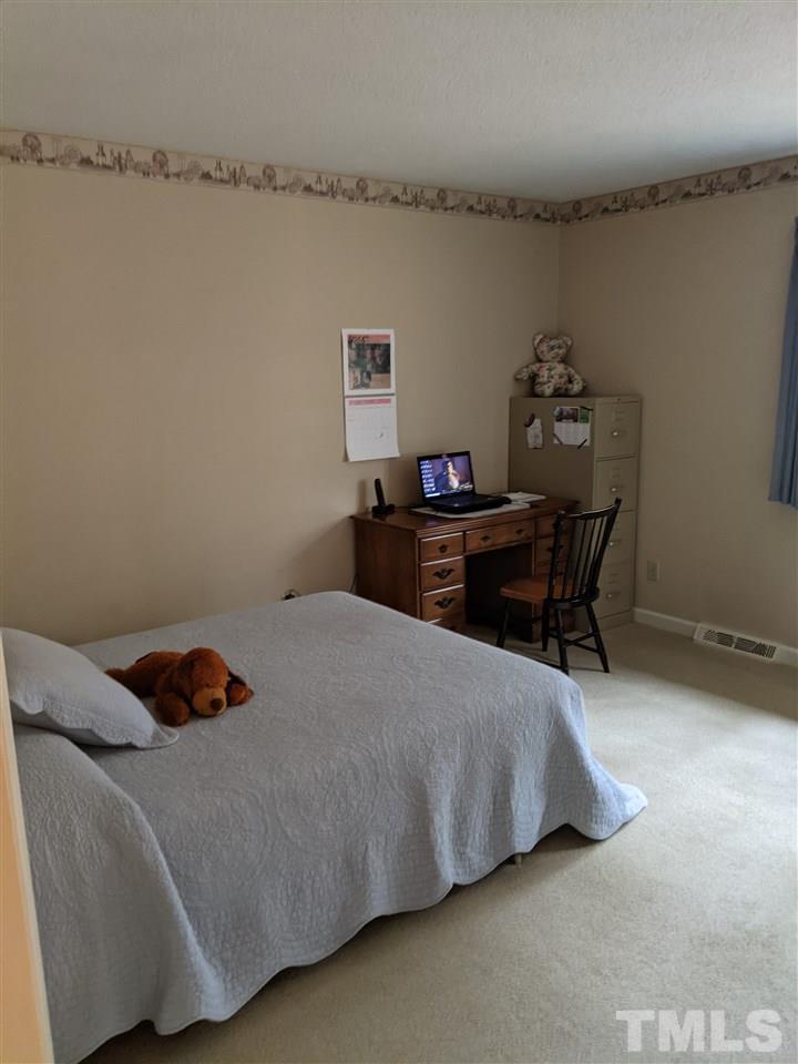 8804 Oneal Road Raleigh, NC 27613 - Photo 5 of 11 a bedroom with a bed and a table in it
