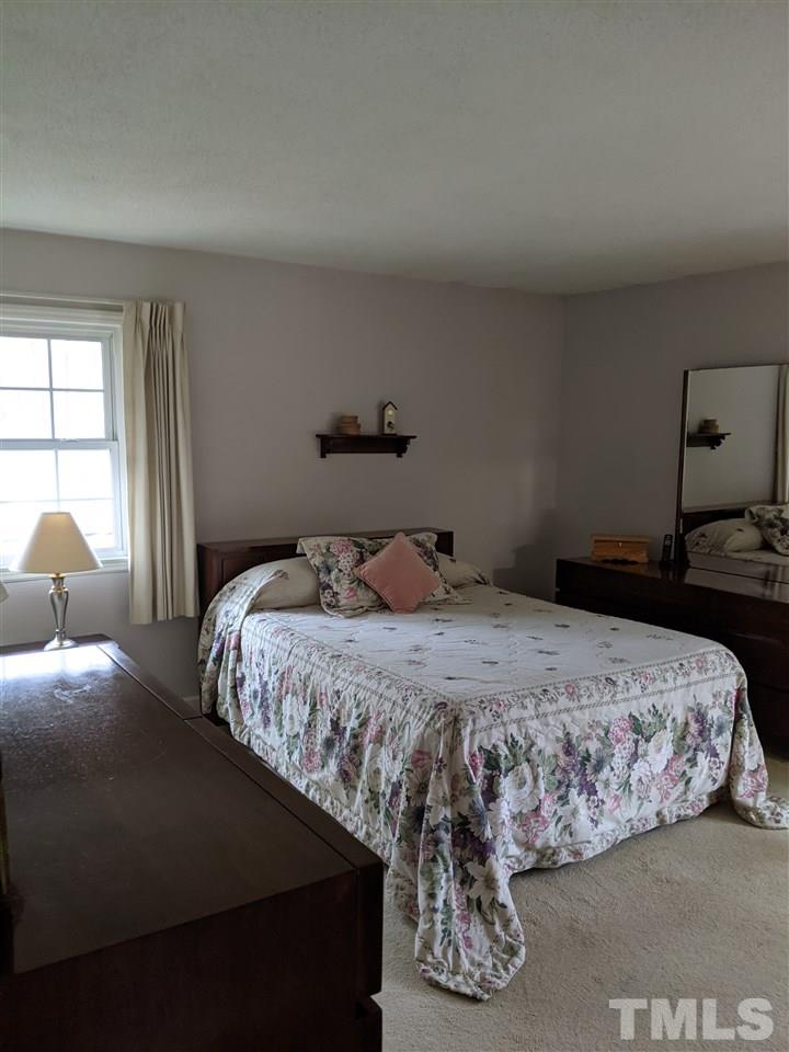 8804 Oneal Road Raleigh, NC 27613 - Photo 7 of 11 a bedroom with a bed and window