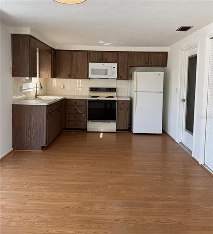 a kitchen with stainless steel appliances a refrigerator sink and microwave