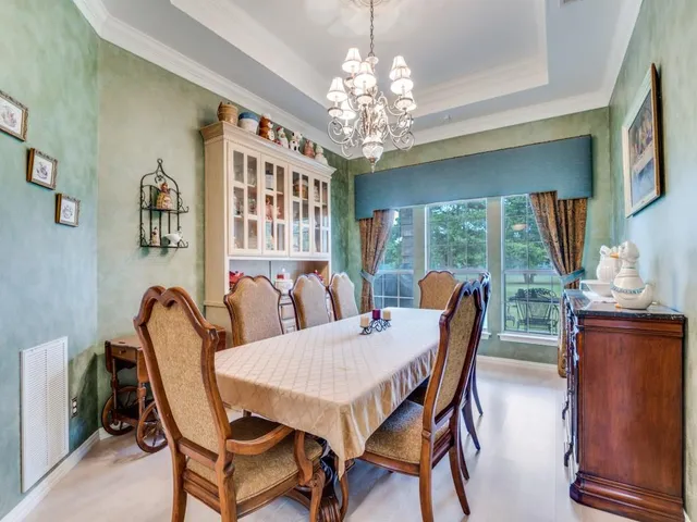 a dining room with furniture a chandelier and window