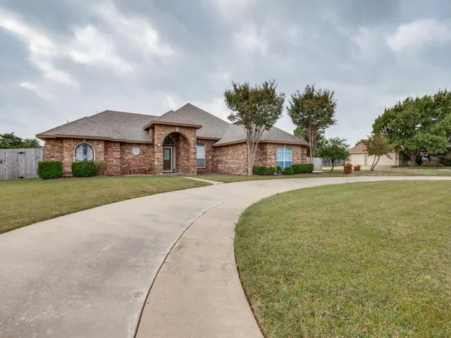 a front view of a house with a yard and potted plants