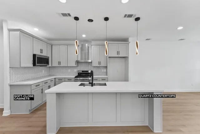 a kitchen with kitchen island a counter top space a sink stainless steel appliances and cabinets