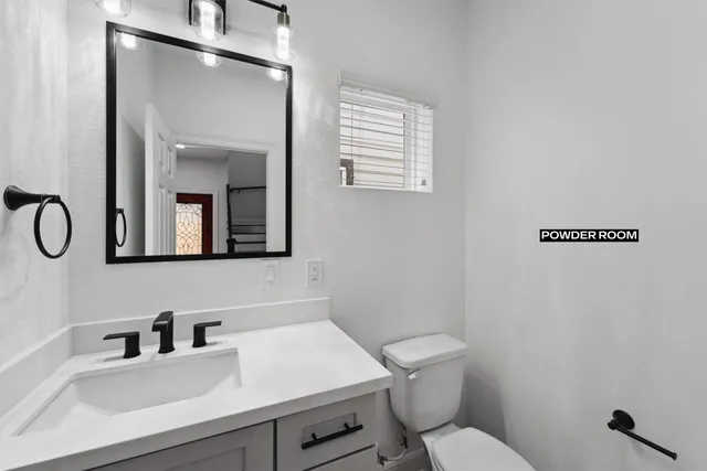 a bathroom with a sink toilet and a mirror