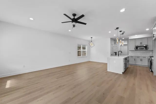 an open kitchen with kitchen island white cabinets and stainless steel appliances