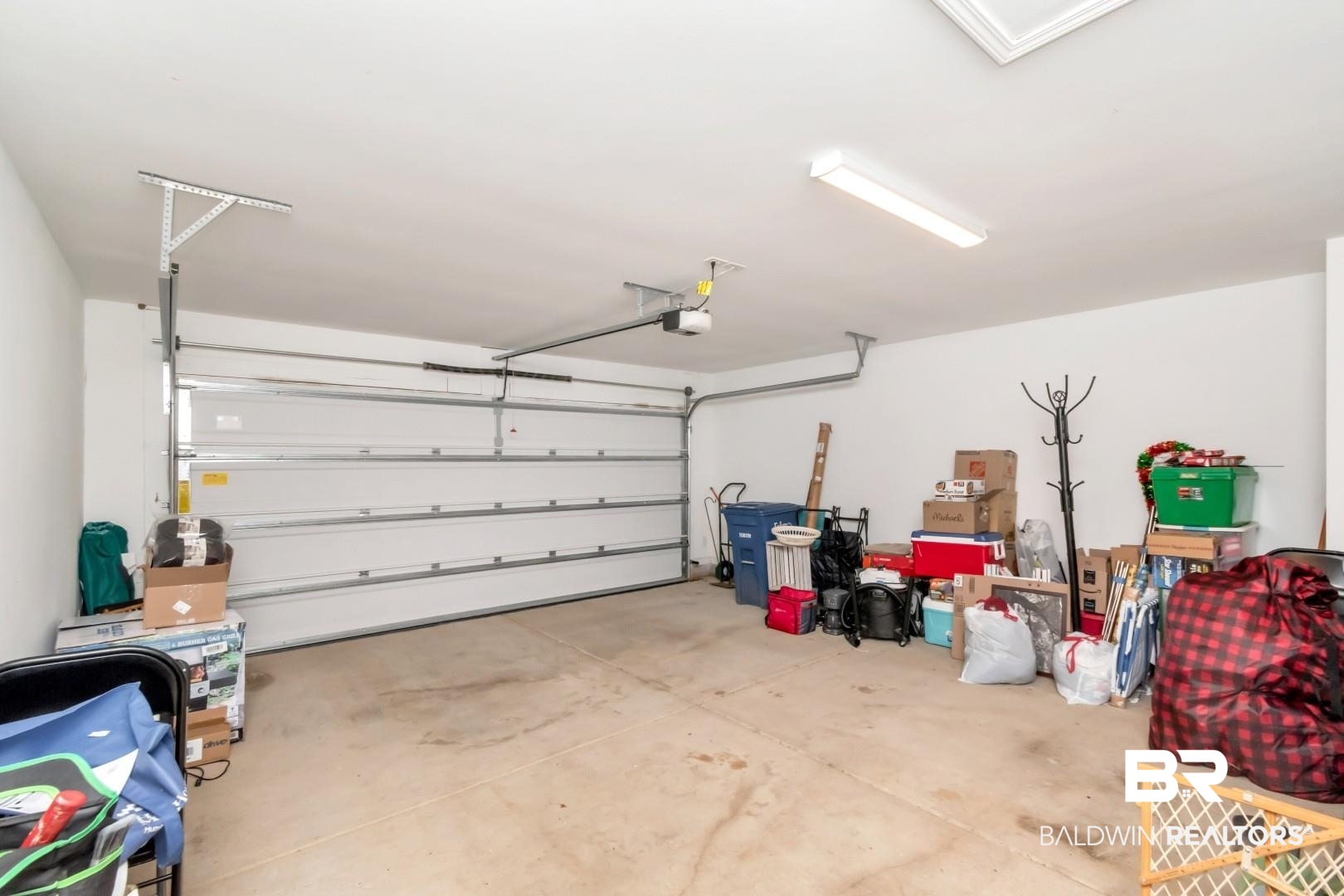1295 Hayward Loop Foley, AL 36535 - Photo 22 of 29 Spacious garage featuring a white overhead door, high ceilings, and a concrete floor