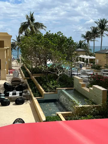 a view of a swimming pool with a yard and sitting area