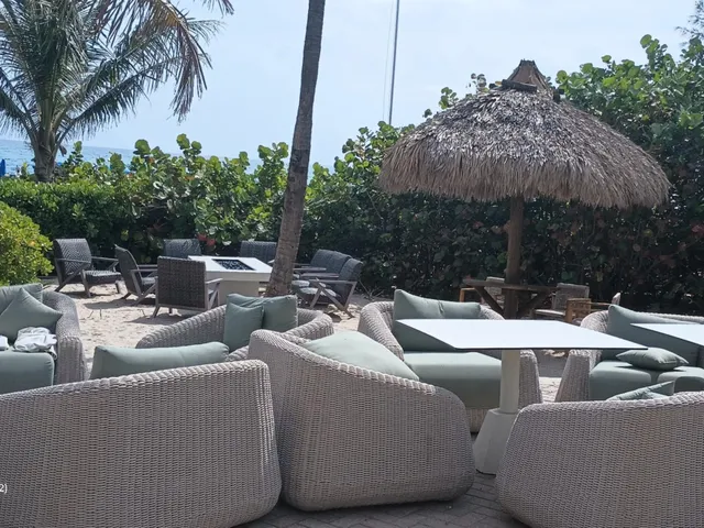a view of a swimming pool with lawn chairs under an umbrella