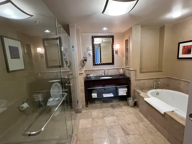 a bathroom with a tub a sink and mirror