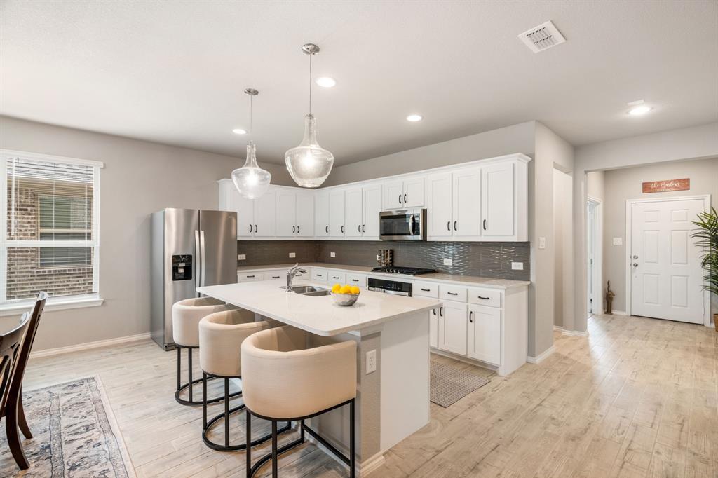321 Pasture Drive Midlothian, TX 76065 - Photo 11 of 40 a kitchen with a dining table chairs refrigerator and cabinets