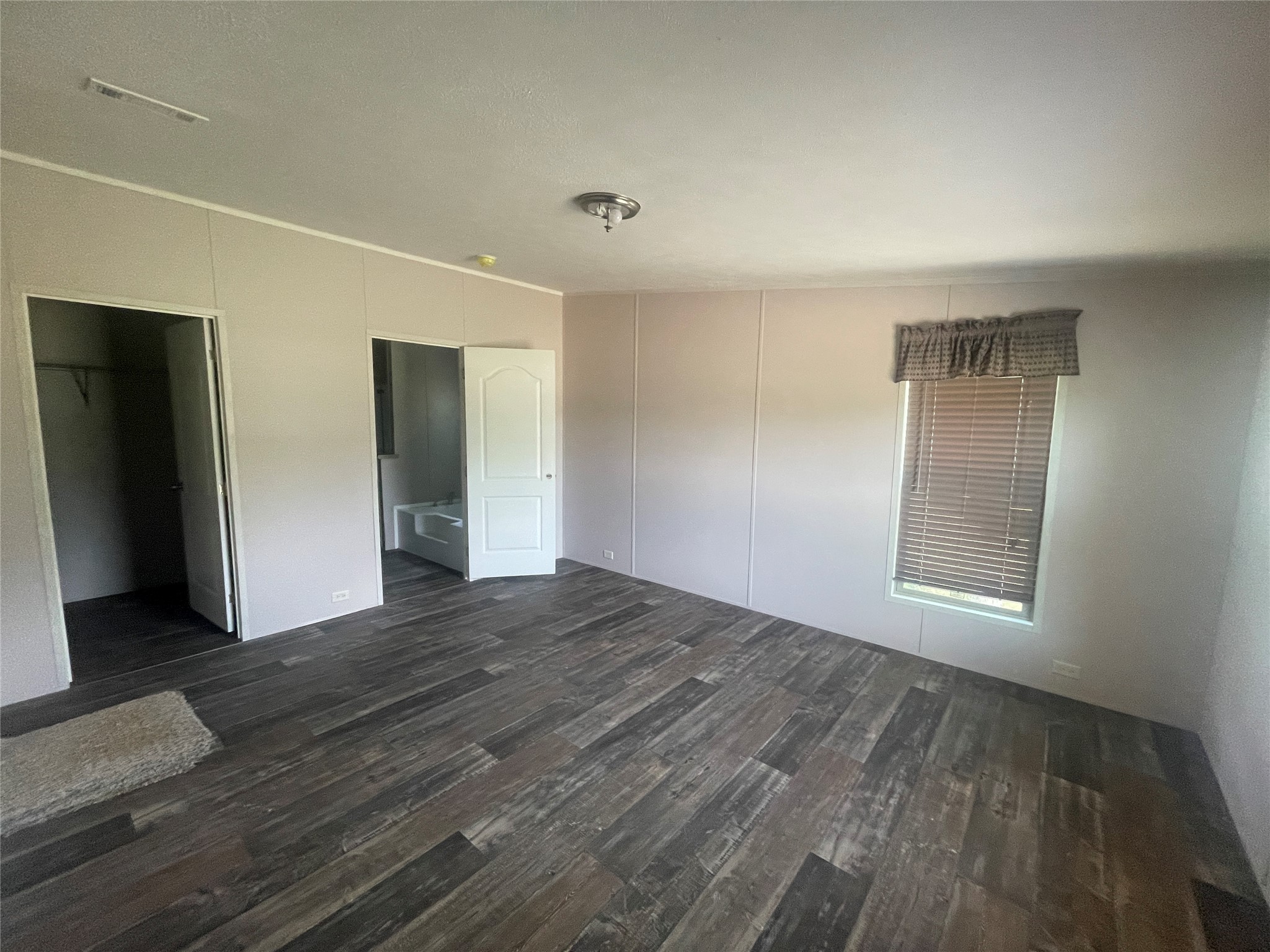 7855 Taylorsville Road Dale, TX 78616 - Photo 6 of 12 An inviting primary bedroom with rich wood flooring and a deep walk-in closet.