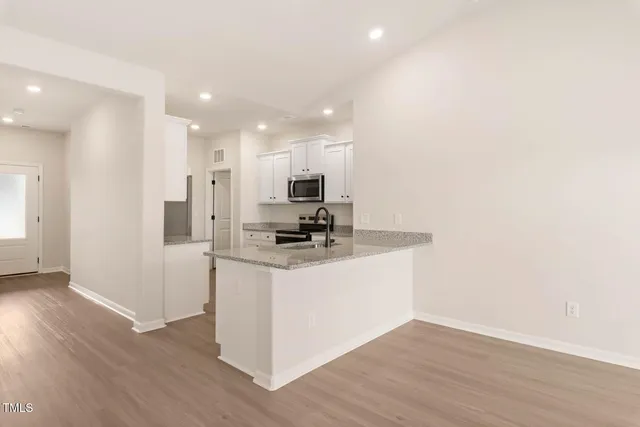 a view of kitchen with stainless steel appliances cabinets and wooden floor