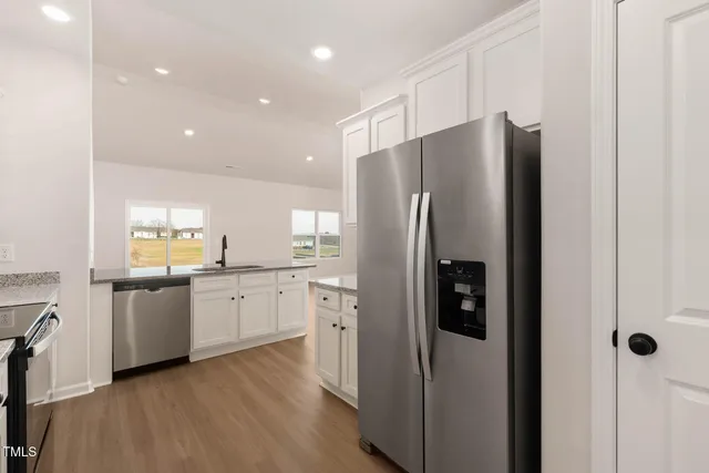 a kitchen with stainless steel appliances a refrigerator and a stove top oven