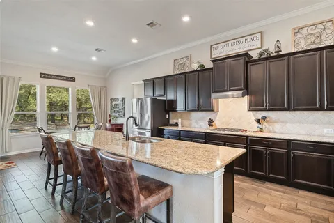 a large kitchen with kitchen island a sink a counter top space and stainless steel appliances