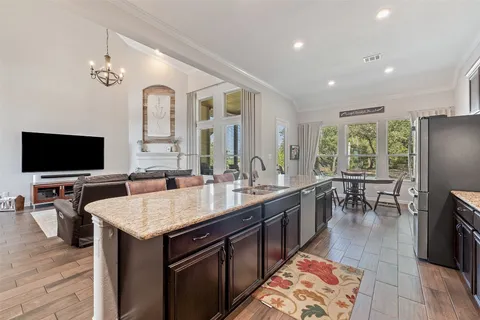 a kitchen with granite countertop lots of counter top space a sink stainless steel appliances and cabinets