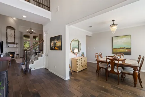 a dining room with furniture a chandelier and wooden floor
