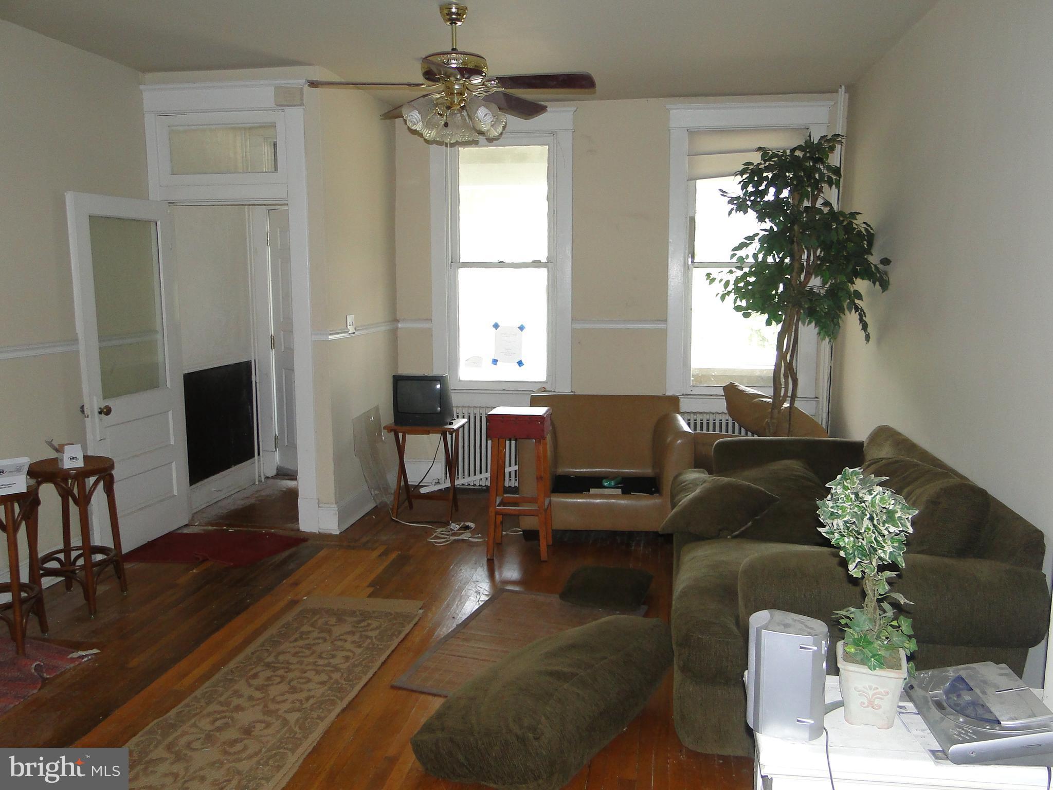 3019 Belair Road Baltimore, MD 21213 - Photo 3 of 11 a living room with furniture a chandelier a rug and a window