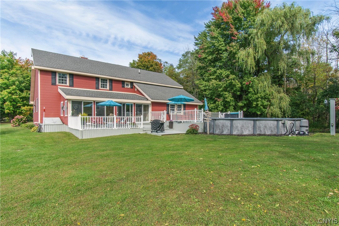 15384 Fuller Road Adams, NY 13606 - Photo 10 of 50 A spacious backyard lawn complements the elevated rear deck and large above-ground pool setup.
