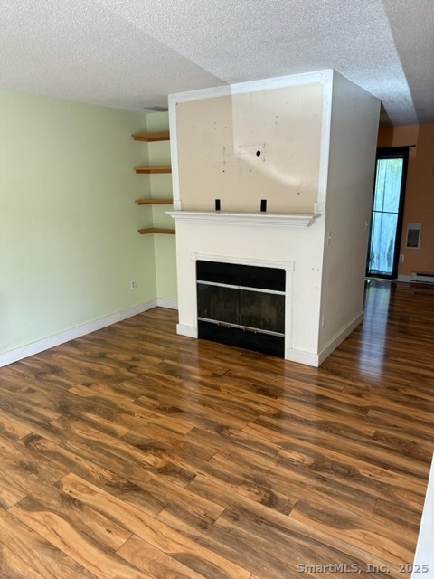 585 Park Road, Unit 108 Waterbury, CT 06708 - Photo 3 of 13 a view of an empty room with wooden floor and a fireplace