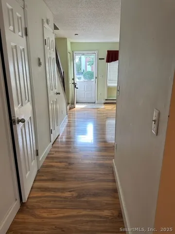 a view of a hallway with wooden floor and stairs