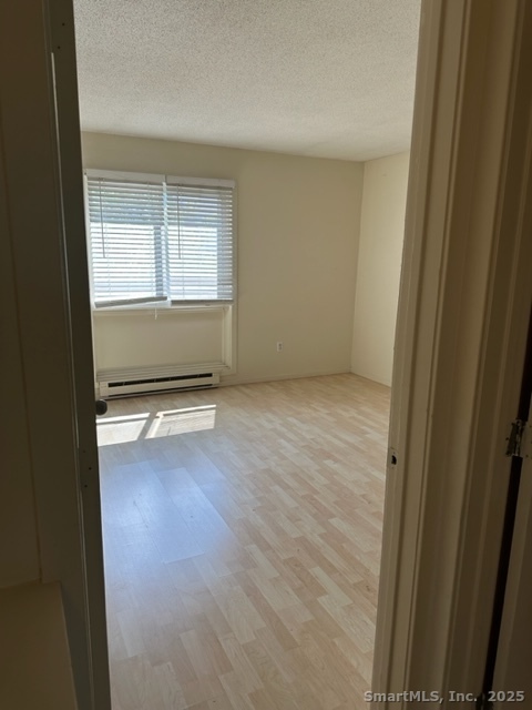 585 Park Road, Unit 108 Waterbury, CT 06708 - Photo 6 of 13 a view of an empty room with wooden floor and a window
