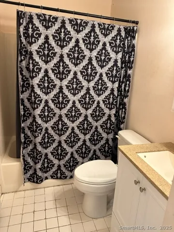 a bathroom with a toilet and a shower curtain