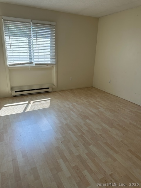 585 Park Road, Unit 108 Waterbury, CT 06708 - Photo 9 of 13 an empty room with wooden floor and windows