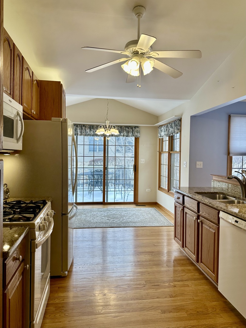 11904 Somerset Road Orland Park, IL 60467 - Photo 13 of 38 a view of kitchen with stainless steel appliances granite countertop a stove top oven a sink and a wooden floor